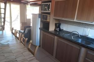 a kitchen with a sink and a counter top at Residencial Flamboyant in Garopaba