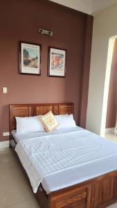 a bed in a bedroom with two pictures on the wall at Hòa An Hotel- Early Morning Check-in in Cao Bằng