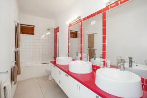 a bathroom with two sinks and a red counter at Pear Tree House Barbados in Saint James +20 photos