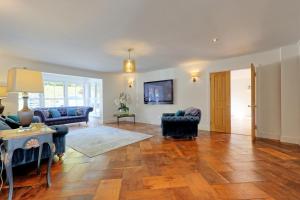 a living room with blue furniture and a wooden floor at Mayrose House - 6BR 4BATH Luxe Spacious Retreat in Takeley