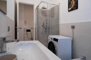 a bathroom with a sink and a washing machine at Casa Margherita in Costa Masnaga