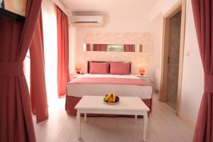 een slaapkamer met een bed en een tafel met een fruitschaal bij Mia Hill Suites in Bodrum City