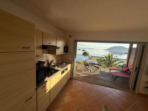 a kitchen with a sliding glass door to a patio at Les oliviers 11 Appartement, bord de mer, porto-vecchio in Porto-Vecchio