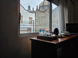 una scrivania con finestra affacciata su un edificio di Casa Monasterio H Boutique a Città del Messico