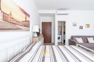 ein weißes Schlafzimmer mit einem Bett und einer Couch in der Unterkunft Borgo Panigale - near the Airport - Polleggio Home in Bologna