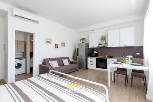 ein Wohnzimmer und eine Küche mit einem Bett und einem Tisch in der Unterkunft Borgo Panigale - near the Airport - Polleggio Home in Bologna + 10 Fotos