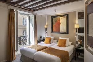 a hotel room with two beds and a window at Best Western Plus Hotel Sydney Opera in Paris