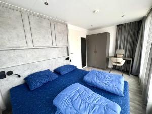 a bedroom with a blue bed with blue pillows at De Maasterp - Woonboot 5 in Montfort