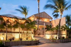 a house with palm trees in front of it at Pousada Vina in Jericoacoara