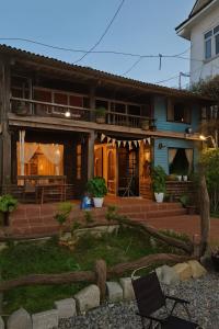 ein Haus mit einer Veranda und einer Terrasse in der Unterkunft Ri's Garden Homestay - Nhà gỗ bên sườn đồi in Da Thien