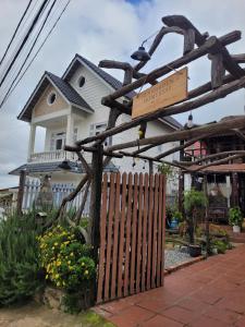 ein Schild vor einem Haus mit einem Zaun in der Unterkunft Ri's Garden Homestay - Nhà gỗ bên sườn đồi in Da Thien + 10 Fotos
