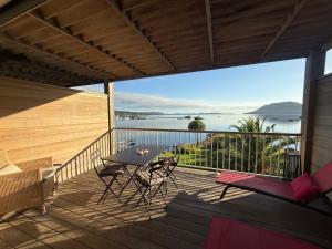 a balcony with a table and chairs and a view of the water at Les oliviers 11 Appartement, bord de mer, porto-vecchio in Porto-Vecchio