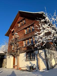 a house with snow covered trees in front of it at Beatli Chalet in Wildhaus