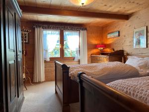 a bedroom with a bed and a window in a room at Beatli Chalet in Wildhaus