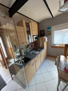 a kitchen with wooden cabinets and a window at Gemütliches Ferienhaus im Herzen von Cuxhaven in Cuxhaven
