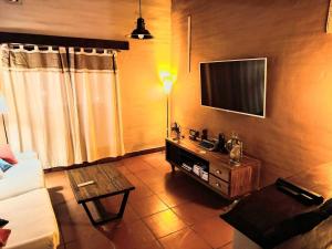Una sala de estar con un sofá y un televisor. en House in Yala - close to La Quebrada, en Yala