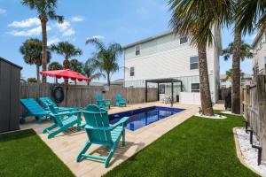 un patio trasero con sillas azules y una piscina en Endless Summer Jax Beach, en Baptist Medical Center/Beaches Heliport