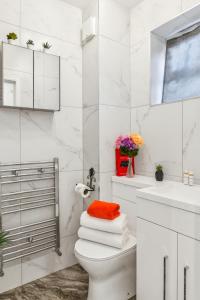 a white bathroom with a toilet and a sink at Deluxe Studio Flat - King's Cross - by KeyHol Holiday Let in London +14 photos