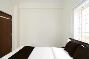 a bedroom with a black and white bed and a window at SPOT ON GN luxury Suits in Hyderabad
