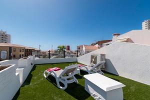 un balcón con 2 tumbonas en el césped en Modern 3 Bedroom Villa Jaccuzi, en Playa Fañabe