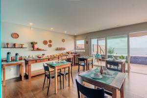 モロ・デ・サンパウロにあるPousada Vila Dos Maresのテーブルと椅子と海のあるダイニングルーム