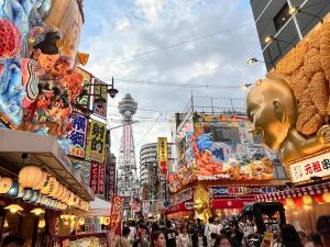 a busy street in a city with people and buildings at Kanchi Guesthouse in Osaka