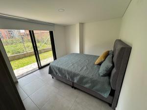 a bedroom with a bed and a large window at House 10 minutes from the airport, Rionegro in Rionegro