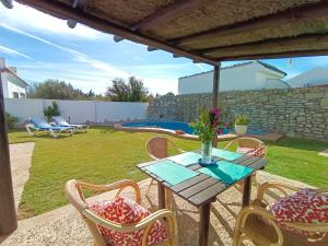drewniany stół i krzesła z wazonem kwiatów w obiekcie Casa Playa w mieście El Palmar