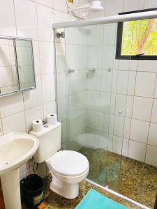 a bathroom with a toilet and a sink and a shower at Pousada Maria Laura in Guararema