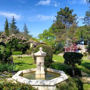 a fountain in the middle of a garden at Les Althéas - Gîte En Ardèche in Chandolas