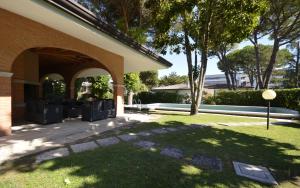 ein Gebäude mit einem Torbogen und einem Rasenhof in der Unterkunft Villa Sabrina in Lignano Sabbiadoro