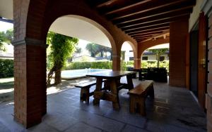 eine Außenterrasse mit Tisch und Bänken in der Unterkunft Villa Sabrina in Lignano Sabbiadoro