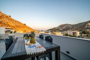 a table on a balcony with a view of the city at Luna in Kalymnos +11 photos