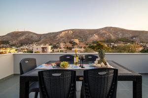 a table with a bottle of wine on a balcony at Luna in Kalymnos