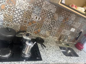a kitchen counter with a stove and a tile wall at AP inteiro no Brás lado igrejas e comércio andar alto Estacionamento a combinar in São Paulo +14 photos