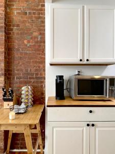 a kitchen counter with a microwave and a table at Cottage 215 Apartments in New York