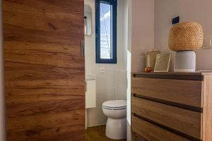 a bathroom with a toilet and a wooden door at Houseboat Toruń in Toruń