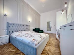 ein Schlafzimmer mit einem großen Bett mit blauem Kopfteil in der Unterkunft Cris & Ema Luxury Downtown Apartment in Arad