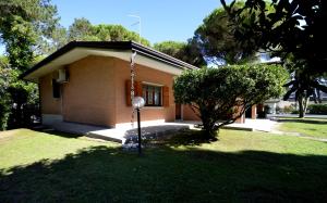 ein kleines Haus mit einem Baum im Hof in der Unterkunft Villa Sabrina in Lignano Sabbiadoro + 23 Fotos