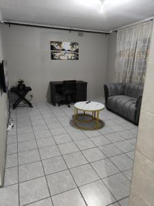una sala de estar con un sofá y una mesa en Tranquil Leisure, en Midrand