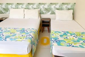a room with two beds and a night stand at Eficiência - Casa DasCli in Camocim