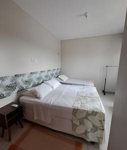a bedroom with a large bed in a white room at Eficiência - Casa DasCli in Camocim