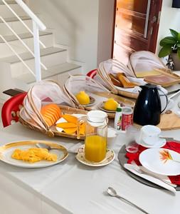 a table topped with plates of food and orange juice at Eficiência - Casa DasCli in Camocim +40 photos