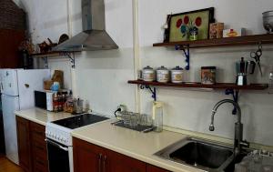 a kitchen with a sink and a stove and a refrigerator at Old soul, Sea views in Dhërmi