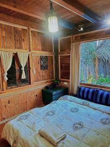 ein Schlafzimmer mit großem Bett und Fenster in der Unterkunft Ri's Garden Homestay - Nhà gỗ bên sườn đồi in Da Thien