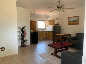 een woonkamer met een bank en een tafel en een keuken bij Green Door Cottage 