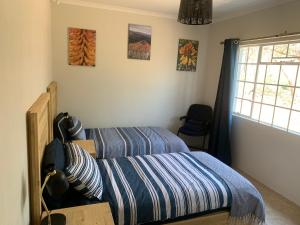 een slaapkamer met twee bedden en een raam bij Green Door Cottage 