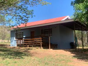 een klein wit gebouw met een rood dak bij Green Door Cottage  +6 foto's