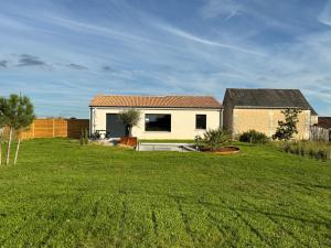 a house in the middle of a green field at Le Logis du Chêne in Vendeuvre-du-Poitou