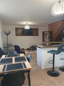 a living room with tables and chairs and a staircase at Maison de campagne in Aignay-le-Duc